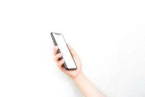 tenant un smartphone à deux mains comme s'il tapait une conversation. un smartphone avec un écran blanc vierge utilisé pour la maquette publicitaire. photo