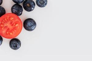 fond de myrtille et de tomate, fond de nourriture, fond de fruits et légumes avec espace de copie pour le texte, ingrédients alimentaires frais pour la cuisine, vue de dessus avec espace de copie, bannière publicitaire alimentaire photo