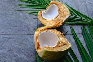 fruits de noix de coco verts frais coupés en deux et feuilles de noix de coco