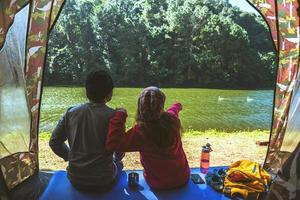 Un couple voyage des tentes de camping dans une forêt de pins au bord du lac du lac pang oug mae hong son, en thaïlande. photo