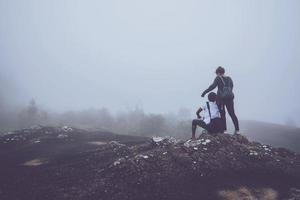 amoureux des femmes et des hommes asiatiques voyagent se détendre pendant les vacances. sur une montagne rocheuse. bois de nature sauvage sur la montagne. photo