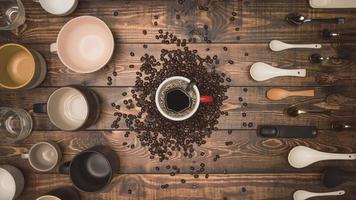 de nombreuses tasses de café avec des grains sur une table en bois, vue de dessus. composition à plat avec des tasses de café sur fond vieux grain de bois. photographie culinaire, boisson. photo