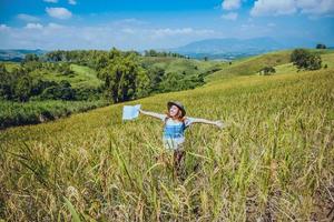 les femmes asiatiques voyagent se détendent pendant les vacances. étendre le champ de montagne de la carte d'enquête. culture de riz ranch sur la colline. Thaïlande photo