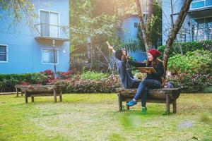 un couple asiatique a souri et était satisfait du livre lu. parmi les magnifiques jardins fleuris, saint valentin photo