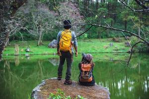 couples asiatiques, détendez-vous en vacances. voyage nature prenant des photographies rose sakura. photo