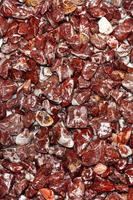 texture bordeaux et blanche de granit rouge humide en morceaux polis, arrondis et polis.