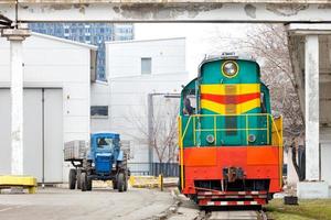 vieux, mais en état de marche, le tracteur locomotive diesel et le tracteur à roues quittent le dépôt. photo