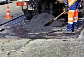 le constructeur de routes verse de l'asphalte frais et renouvelle une partie de la route pour réparation. photo