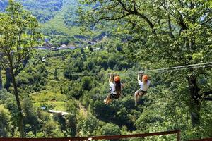 les touristes traversent le long chemin à travers la montagne et la forêt à travers la rivière Tiara en téléphérique. photo