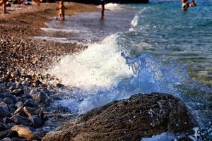 éclaboussure de la vague de la mer sur un gros rocher sur la plage de la mer. photo