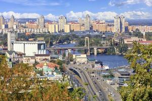 le paysage de la ville d'automne de kyiv avec vue sur le fleuve dnipro, de nombreux ponts, l'ancien quartier podilsky et les nouvelles maisons sur obolon. photo