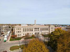 Palais de justice du comté de Kenosha par temps clair avec des véhicules de diffusion télévisée présents pour la couverture du procès. arbres aux couleurs d'automne présents. photo