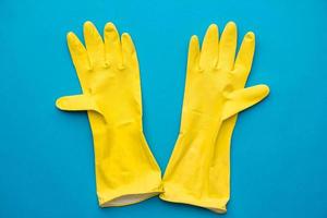 gants en caoutchouc jaune sur fond bleu photo