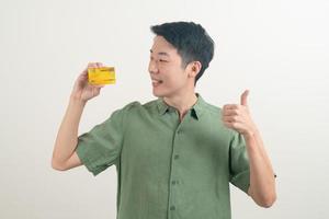 jeune homme asiatique tenant une carte de crédit photo