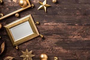 cadre photo et boule de noël en or, ornement de décoration en étoile sur une table en bois marron