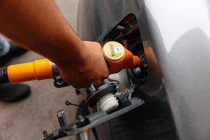 homme de main recharge et remplissage de gazole à la station. pompage de l'essence dans la voiture à la station-service. photo