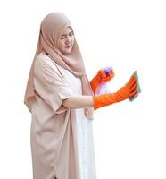 femme musulmane nettoyant la vitre de la porte avec du tissu et de l'alcool en vaporisateur sur fond blanc photo