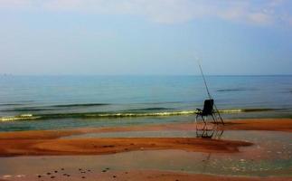 une chaise de pêche solitaire sur le rivage à la fin de l'été photo