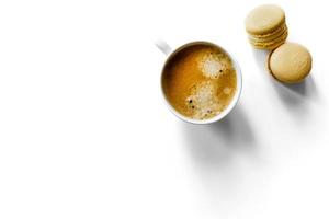 tasse à expresso blanche sur fond blanc avec des macarons. photo