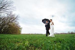 les mariés un jour de mariage pluvieux marchant photo