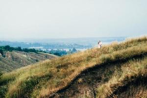 un gars avec une fille en vêtements légers sur le fond d'un canyon vert photo