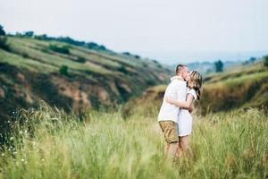 un gars avec une fille en vêtements légers sur le fond d'un canyon vert photo