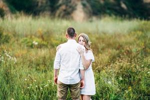 un gars avec une fille en vêtements légers sur le fond d'un canyon vert photo