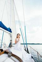 Jeune fille sur le pont du yacht en bois à voile photo