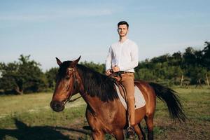 gars en chemise blanche sur une promenade avec des chevaux bruns photo