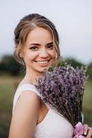 fille dans une robe d'été blanche et un gars dans une chemise blanche sur une promenade au coucher du soleil avec un bouquet photo