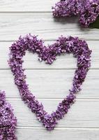 cadre de branches et de fleurs de lilas en forme de coeur photo