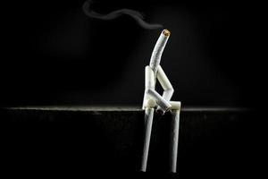 image d'un personnage en cigarette, seul et triste sur fond noir. concept de dépendance au tabagisme, fumeur voulant arrêter de fumer mais avec difficulté.