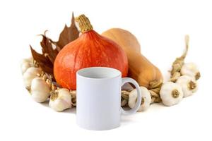 maquette d'une tasse blanche, de citrouilles et d'ail sur fond blanc photo