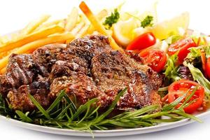 steak grillé, frites et légumes sur fond blanc