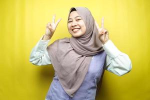 belle jeune femme musulmane asiatique souriante avec confiance, face à la caméra isolée sur fond jaune