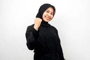 belle jeune femme musulmane asiatique souriante confiante, enthousiaste et joyeuse avec les mains serrées, signe de succès, coups de poing, combats, pas peur, victoire, isolé sur fond blanc photo