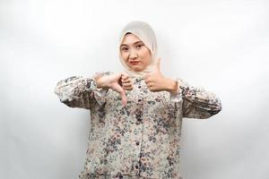 belle jeune femme musulmane asiatique avec signe de la main aime ou n'aime pas, oui ou non, heureuse ou triste, comparant deux choses, isolées sur fond blanc photo