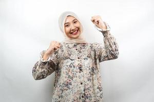 belle jeune femme musulmane asiatique souriante confiante, enthousiaste et joyeuse avec les mains serrées, signe de succès, coups de poing, combats, pas peur, isolé sur fond blanc