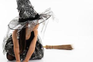 Portrait petite fille asiatique s'habiller en sorcière mignonne pour costume d'halloween avec balai