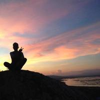 silhouette d'un homme assis sur un fond de ciel orange. photo