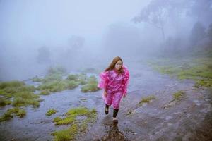 touriste avec manteau de pluie rose marche voyage aventure nature dans la forêt tropicale. voyage nature, voyage détente, voyage thaïlande, saison des pluies. photo