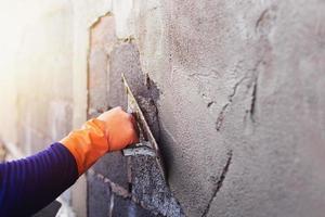 plâtriers en béton pour créer des murs de fond d'ouvriers industriels avec des outils de plâtrage. photo