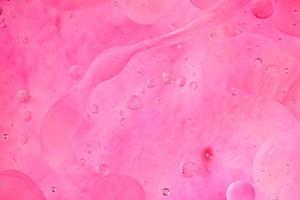 photo d'huile sur une surface d'eau avec des bulles. rose tendre. abstrait coloré.