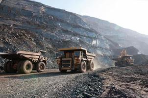 Les camions à benne basculante de la mine à ciel ouvert conduisent seuls la zone industrielle de la carrière de minerai de fer photo