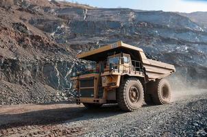 Les camions à benne basculante de la mine à ciel ouvert conduisent seuls la zone industrielle de la carrière de minerai de fer photo