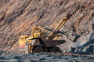 Les camions à benne basculante de la mine à ciel ouvert conduisent seuls la zone industrielle de la carrière de minerai de fer photo