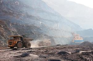 Les camions à benne basculante de la mine à ciel ouvert conduisent seuls la zone industrielle de la carrière de minerai de fer photo