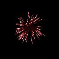des feux d'artifice rouge foncé éclatent dans l'air illuminent le ciel avec un spectacle éblouissant et des festivals de feux d'artifice colorés sur fond noir. photo