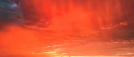 nuages orange et gris belle ambiance de coucher de soleil avec un grand soleil jaune et orange dans les collines de la surface du ciel. photo