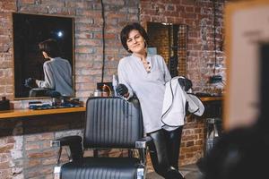 femme de coiffure avec des ciseaux à disposition dans le salon de barbashop photo